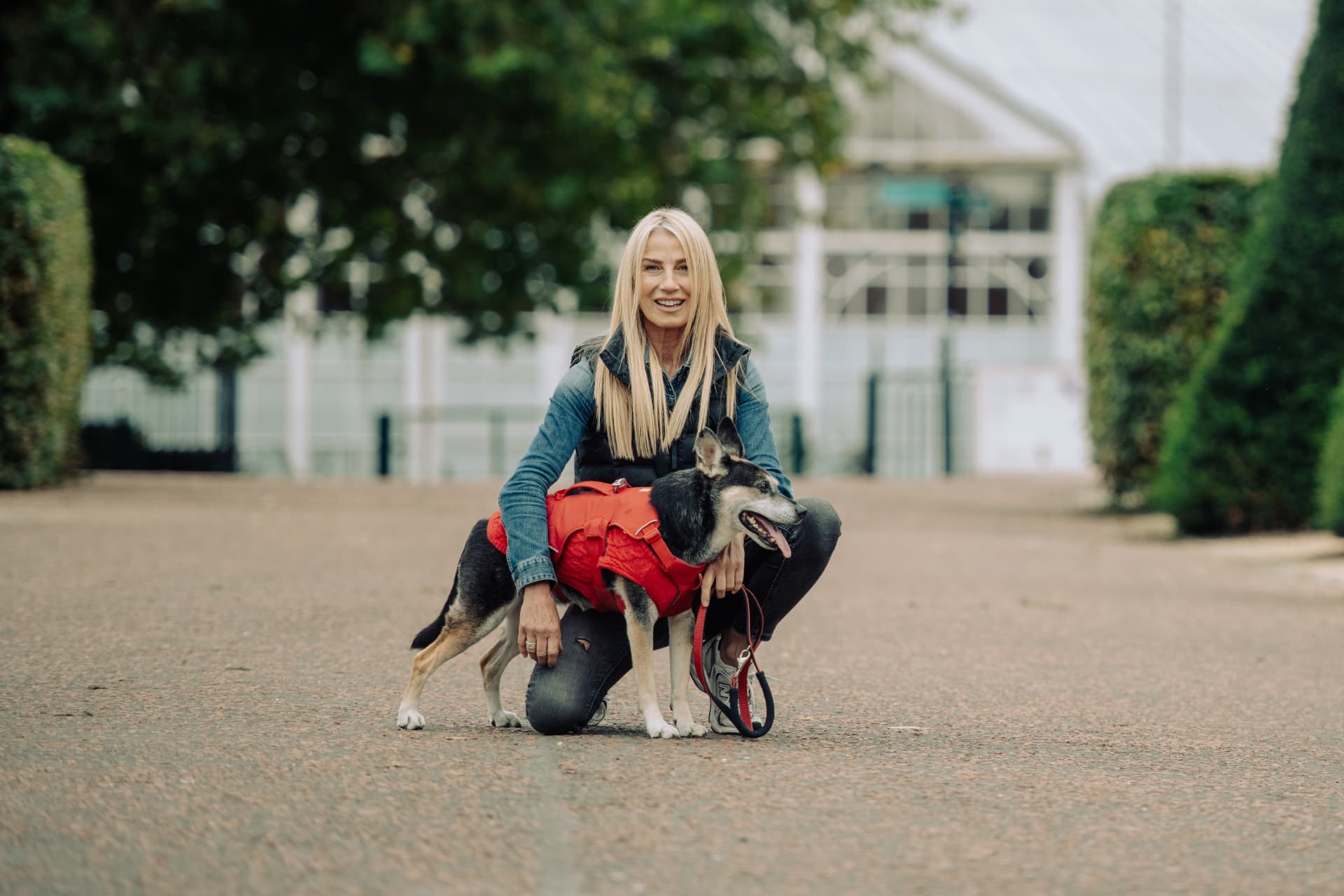 Glasgow behaviour consultant Helen Hutcheson kneeling beside a dog in a red coat