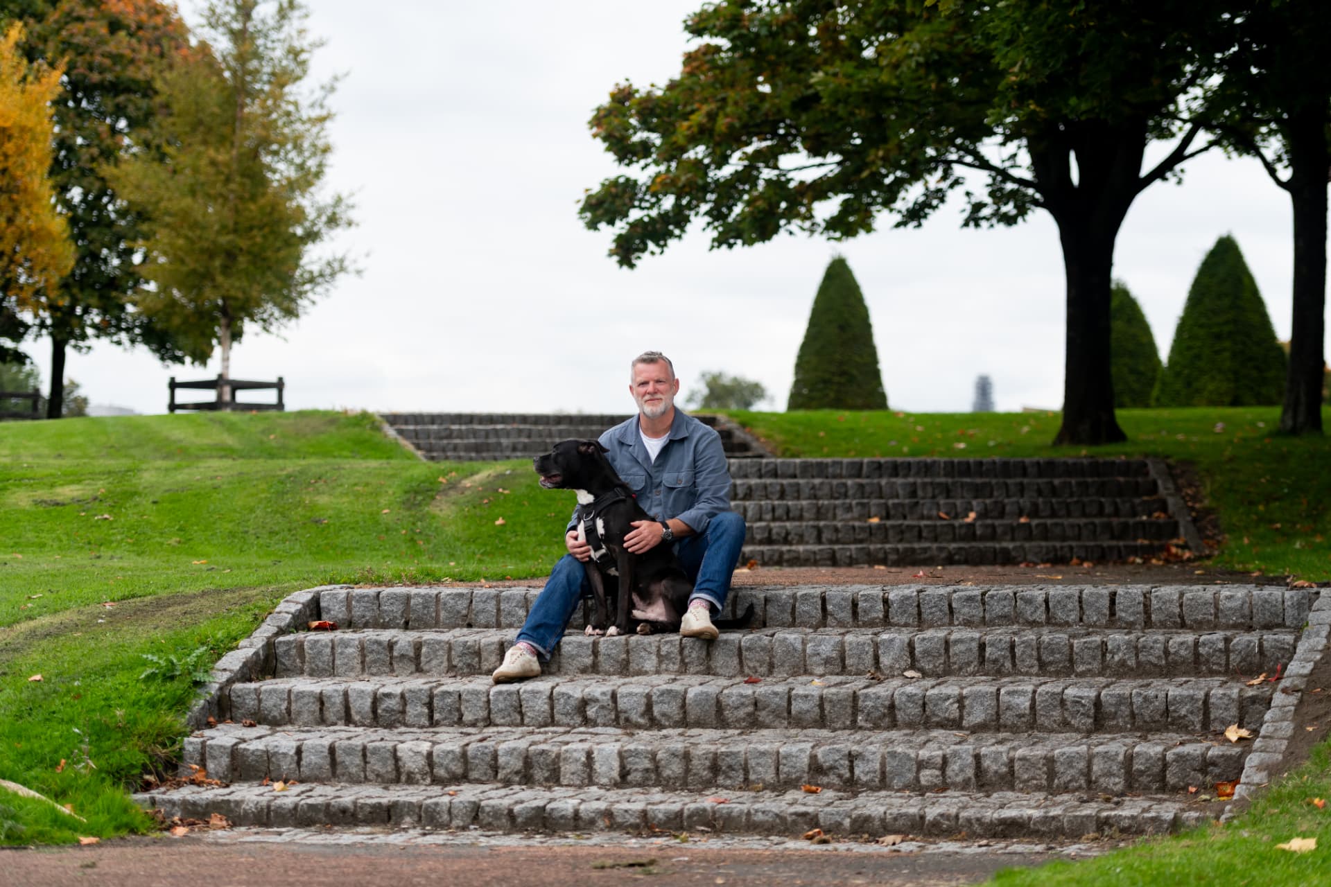 Wide view of a calm settle exercise on park steps during Glasgow dog training