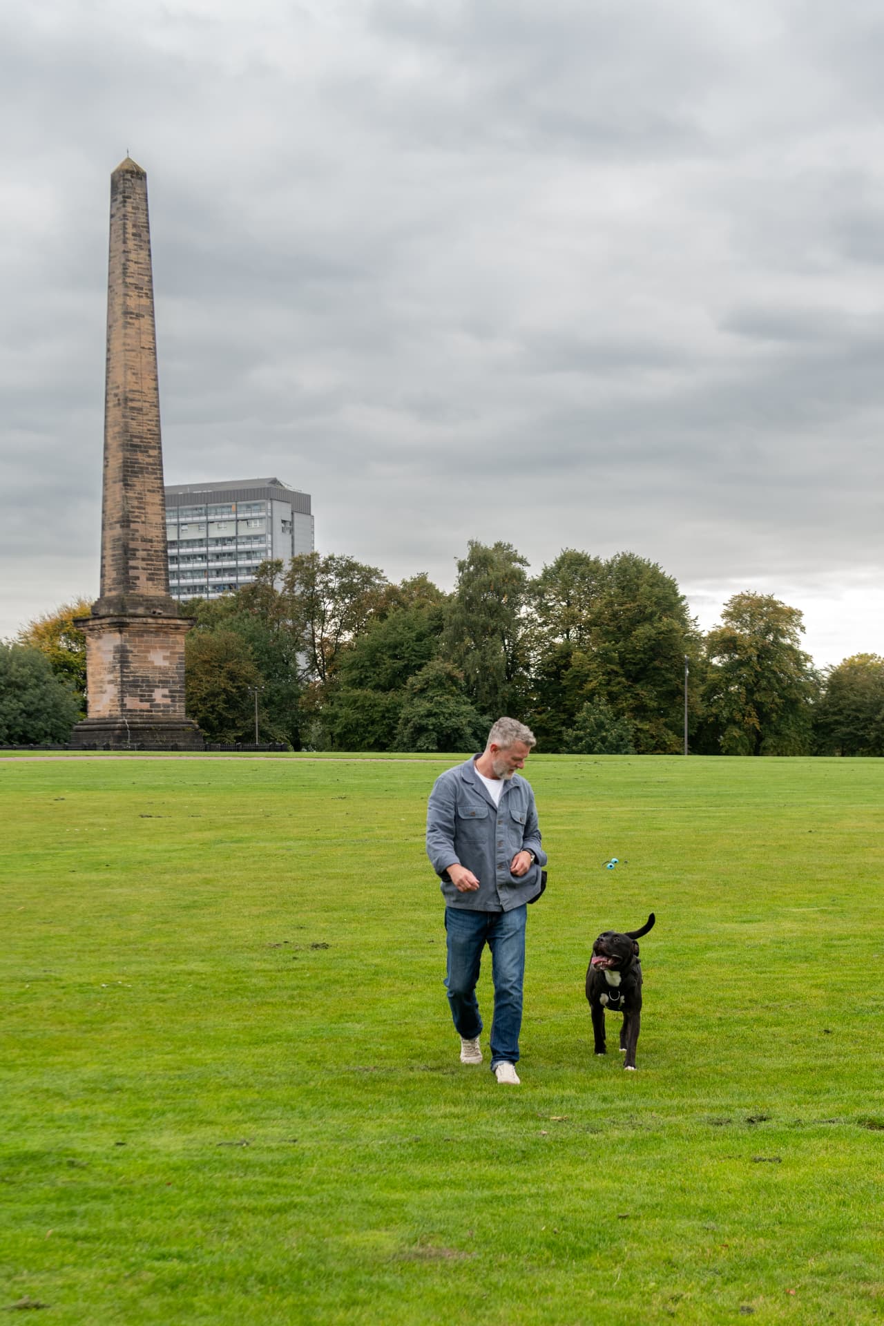 Loose-lead walking practice with a black Labrador on a Glasgow park path